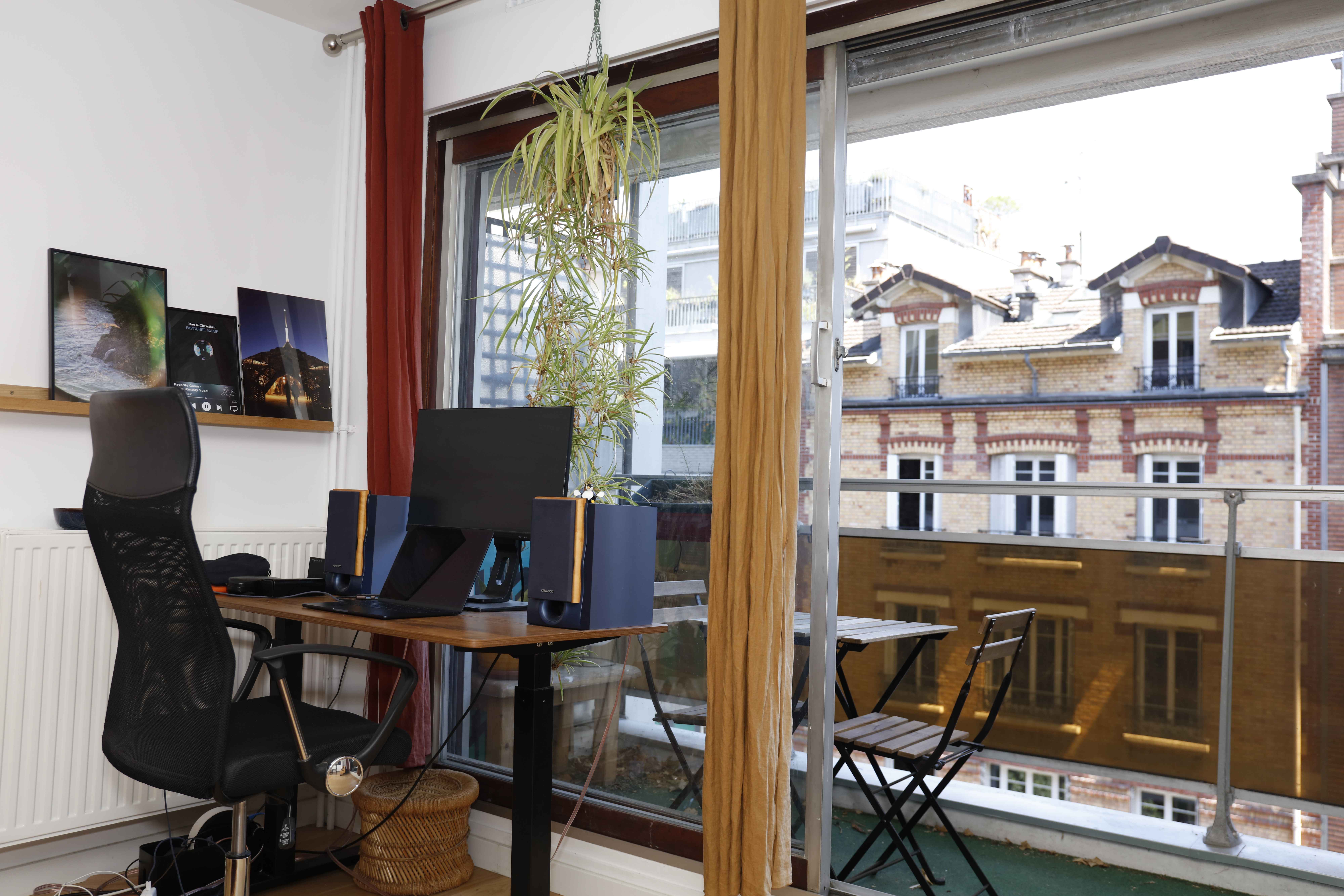 Dual monitor workspace with Parisian rooftop views